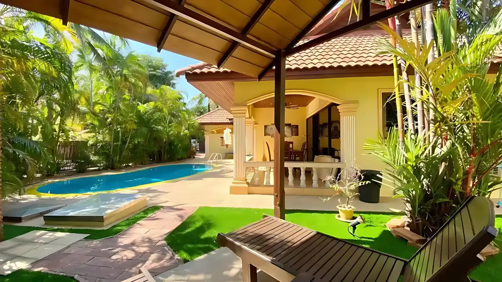 Coconut Paradise Villa lush garden beside pool